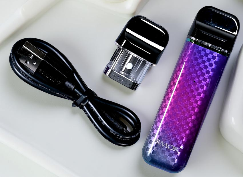 Image showing the unboxed contents of the SMOK NOVO 3 Kit, including the Novo 3 device, two Novo 3 Mesh 0.8Ω Pods, and the USB cable.